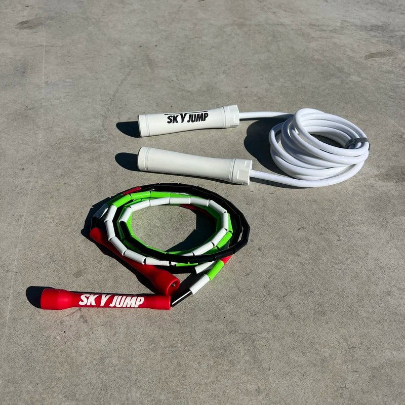 Corde lestée blanche 500g Skyjump avec poignées blanches et corde perlée aux couleurs du drapeau palestinien Skyjump avec poignées rouges.