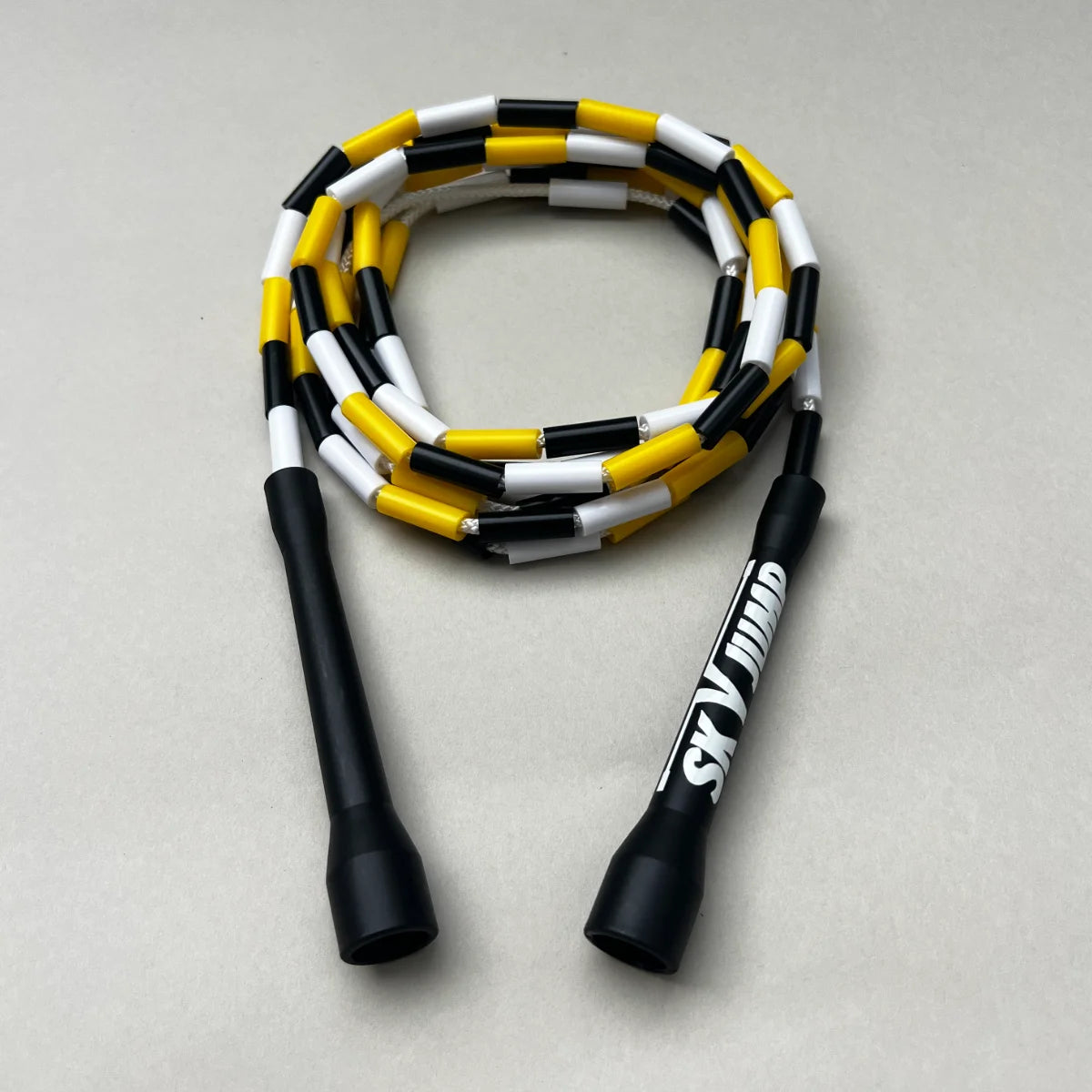 Corde à sauter perlée Sky Fusion enroulée avec poignées ergonomiques noires.