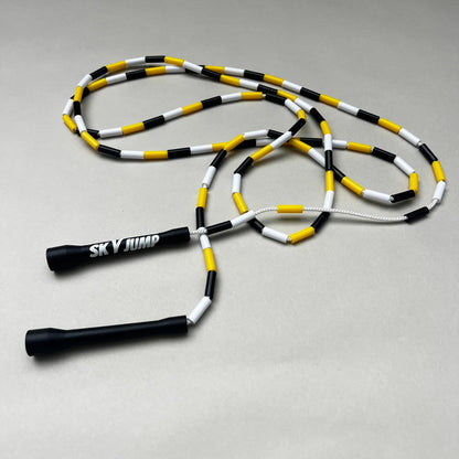 Corde à sauter perlée Sky Fusion entièrement dépliée, noire, jaune et blanche.